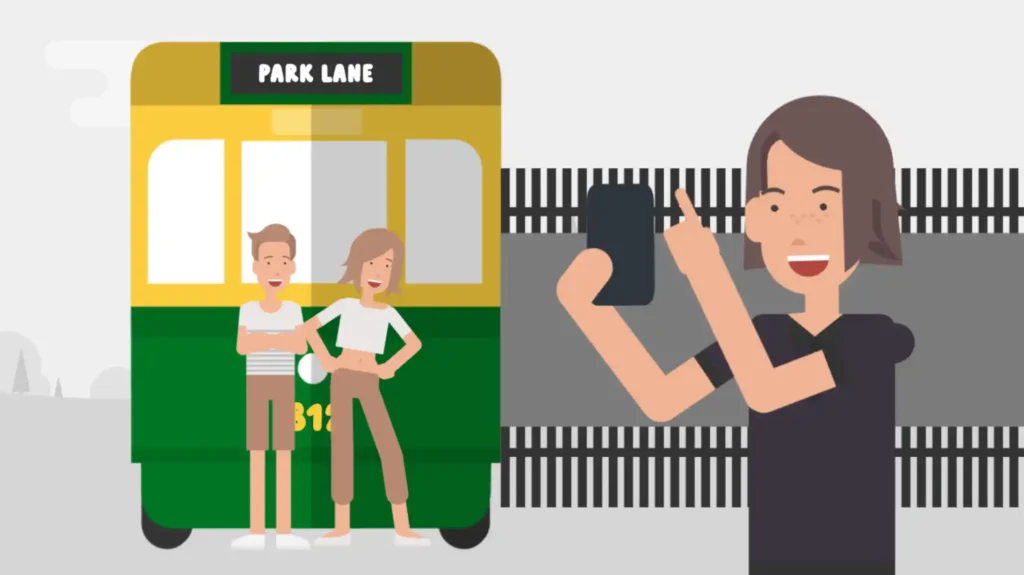 Person taking a photo with a smartphone of two customers posing in front of a green and yellow bus labeled 